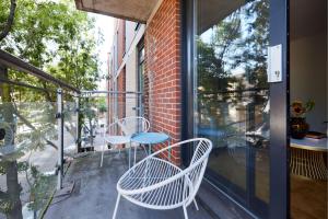 a patio with three chairs and a table on a balcony at The Whitechapel Place - Stunning 2BDR Flat with Balcony in London