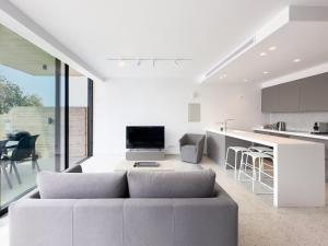 a living room with a couch and a kitchen at Sunset Park Villas in Paphos