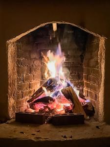 a brick fireplace with a fire in it at Unicorn Reborn - Peaceful Rentals in San Marcos La Laguna