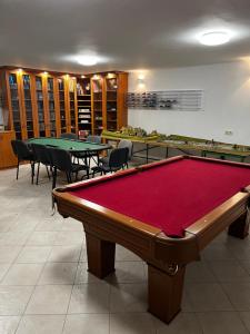 a pool table in a room with tables and chairs at Füle-Müle Élményház in Füle