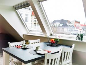 a table and chairs in a room with a window at Herzmuschel in Norderney +7 photos