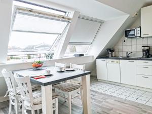 a kitchen with white cabinets and a table and chairs at Herzmuschel in Norderney