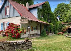 una casa con techo rojo y flores en el patio en Viini puhkemaja en Myustelʼ