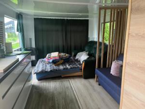 1 dormitorio con cama, sofá y ventana en Domek holenderski -noclegi, en Mielno