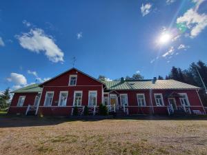 een rood huis met de zon in de lucht bij Kokon Hovi in Kauhajoki