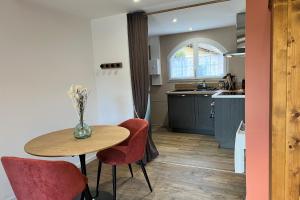 a kitchen with a table and two chairs and a table at Studio Lac chalain 30 m2 piscine chauffe in La Châtelaine +15 photos