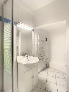 bagno bianco con lavandino e specchio di APPARTEMENT DANS CENTRE HISTORIQUE a Grasse