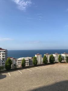 a parking lot with buildings and the ocean in the background at Ultra lüx Klimalı Daire in Trabzon