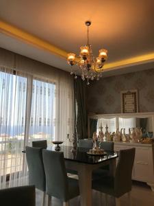 uma sala de jantar com uma mesa e cadeiras e um lustre em Ultra lüx Klimalı Daire em Trabzon