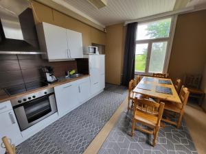 a kitchen with white cabinets and a table with chairs at Kokon Hovi in Kauhajoki