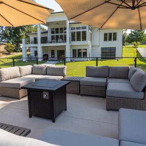 a patio with couches and tables and umbrellas at The Shoal Creek Chateau Lake House in Florence