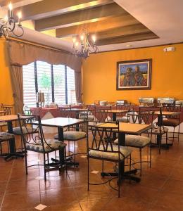 um restaurante com mesas e cadeiras num quarto em Hotel Villa Terra em San Salvador