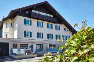 a large white building with blue windows at Ferienwohnung an der Ammer in Oberammergau