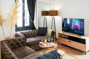 a living room with a couch and a television at AU COEUR DES MONTAGNES in Pierrefitte-Nestalas