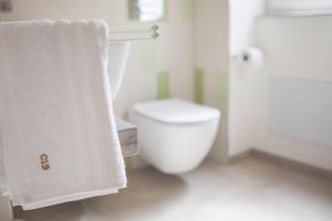 La salle de bains blanche est pourvue de toilettes et d'une serviette. dans l'établissement Candelieri19, à Modica