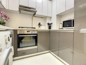 a kitchen with a stove and a microwave at Key View - Glitz 3, Tower 2 in Dubai