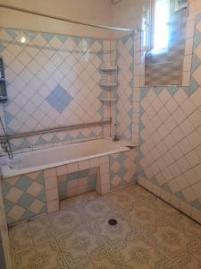 uma casa de banho em azulejo com um lavatório e uma prateleira em individual low-budget guest-house em Tsqaltubo