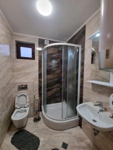 een badkamer met een douche, een toilet en een wastafel bij Bed & Breakfast Sjaj in Sarajevo
