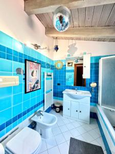 a blue tiled bathroom with a toilet and a sink at The Style Studio in Milan