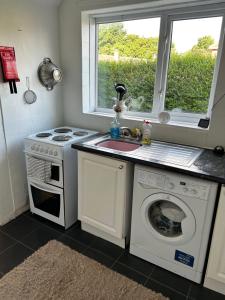 eine Küche mit einer Waschmaschine und einem Waschbecken in der Unterkunft Holly in Middlesbrough