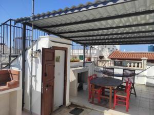 eine Pergola auf einem Balkon mit einem Tisch und Stühlen in der Unterkunft Dimora Kettino in Mola di Bari