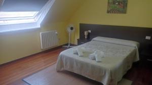 1 dormitorio con 1 cama con toallas en El Rincón de Rebe, en Melide