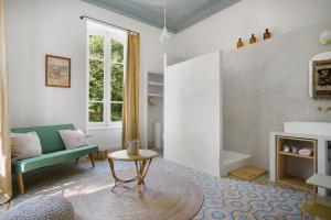 a living room with a green couch and a table at B&B Maison Felisa in Sabran