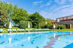 ペスキエーラ・デル・ガルダにあるApartment in Peschiera del Garda - Gardasee 27141の大型スイミングプール(椅子、パラソル付)