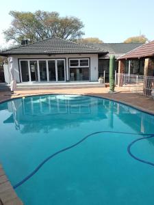 a swimming pool in front of a house at Just B Zone Guest House in Johannesburg