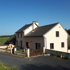 una casa blanca con techo negro en una calle en Grand gite peyrau aubrac loup gévaudan lozère A75 en Aubigeyres