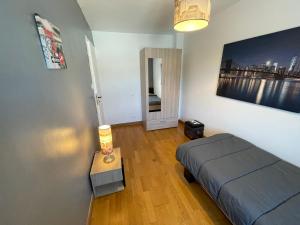 1 dormitorio con 1 cama y 1 mesa con lámpara en Grand gite peyrau aubrac loup gévaudan lozère A75 en Aubigeyres