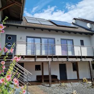 une maison avec des panneaux solaires sur le toit dans l'établissement Ferienwohnung mit Balkon, à Oberelsbach