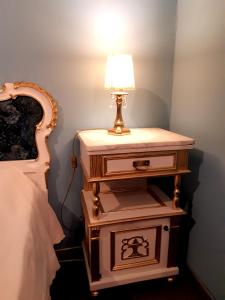 a nightstand with a lamp on it next to a bed at Affittacamere Girasole in Trieste