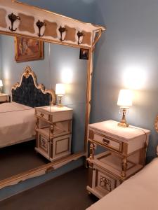 トリエステにあるAffittacamere Girasoleのベッドルーム1室(大きな鏡、ナイトスタンド付)