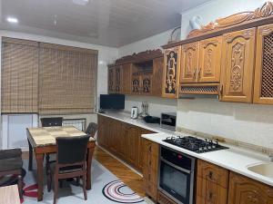 una cucina con armadi in legno, un tavolo e una sala da pranzo di Shamsi’s Apartment a Baku