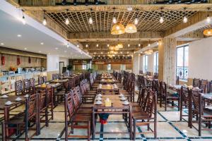 a long dining room with wooden tables and chairs at Grand Flamant Hotel Sapa in Sa Pa