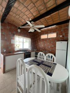 a kitchen with a table and chairs and a ceiling fan at HOTEL VILLAS EL DORADO in Rincon de Guayabitos