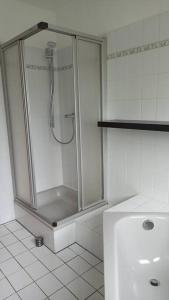 La salle de bains est pourvue d'une douche avec une porte en verre. dans l'établissement Wohnung mit Spielplatz, Kaninchen und Whirlpool, à Grafenhausen