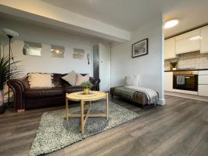 uma sala de estar com um sofá e uma mesa em HUGE Apartment - 12min to City - FREE parking - Contractor Friendly - IRWELL STAYS em Manchester