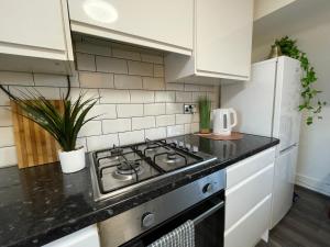 a kitchen with a stove top oven next to a refrigerator at HUGE Apartment - 12min to City - FREE parking - Contractor Friendly - IRWELL STAYS in Manchester