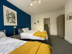 2 camas en una habitación con paredes azules en HUGE Apartment - 12min to City - FREE parking - Contractor Friendly - IRWELL STAYS en Mánchester