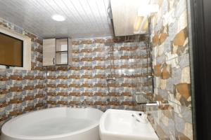 a bathroom with a tub and a sink at Villa Flo Residence in Lomé