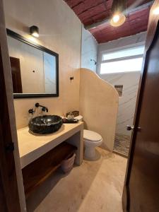 a bathroom with a sink and a toilet and a mirror at HOTEL VILLAS EL DORADO in Rincon de Guayabitos