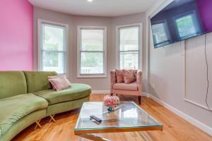 a living room with a green couch and a glass table at Vibrant East Orange Townhome Near Red Bull Arena! in East Orange