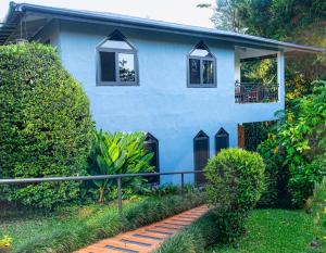 a blue house with windows and a walkway at Hotel Isla Verde in Boquete