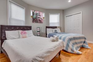 a bedroom with two beds and two windows at Vibrant East Orange Townhome Near Red Bull Arena! in East Orange