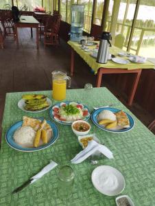 una mesa con platos de comida y bebidas. en Amazon Wonder Expeditions, en Iquitos