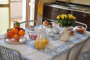 un tavolo con una tovaglia blu e bianca con frutta e fiori di Giangurgolo B&B a Rende
