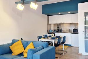 uma sala de estar com um sofá azul e uma mesa com almofadas amarelas em Milano 3 Suite em Basiglio