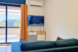 uma sala de estar com um sofá e uma televisão de ecrã plano em Milano 3 Suite em Basiglio